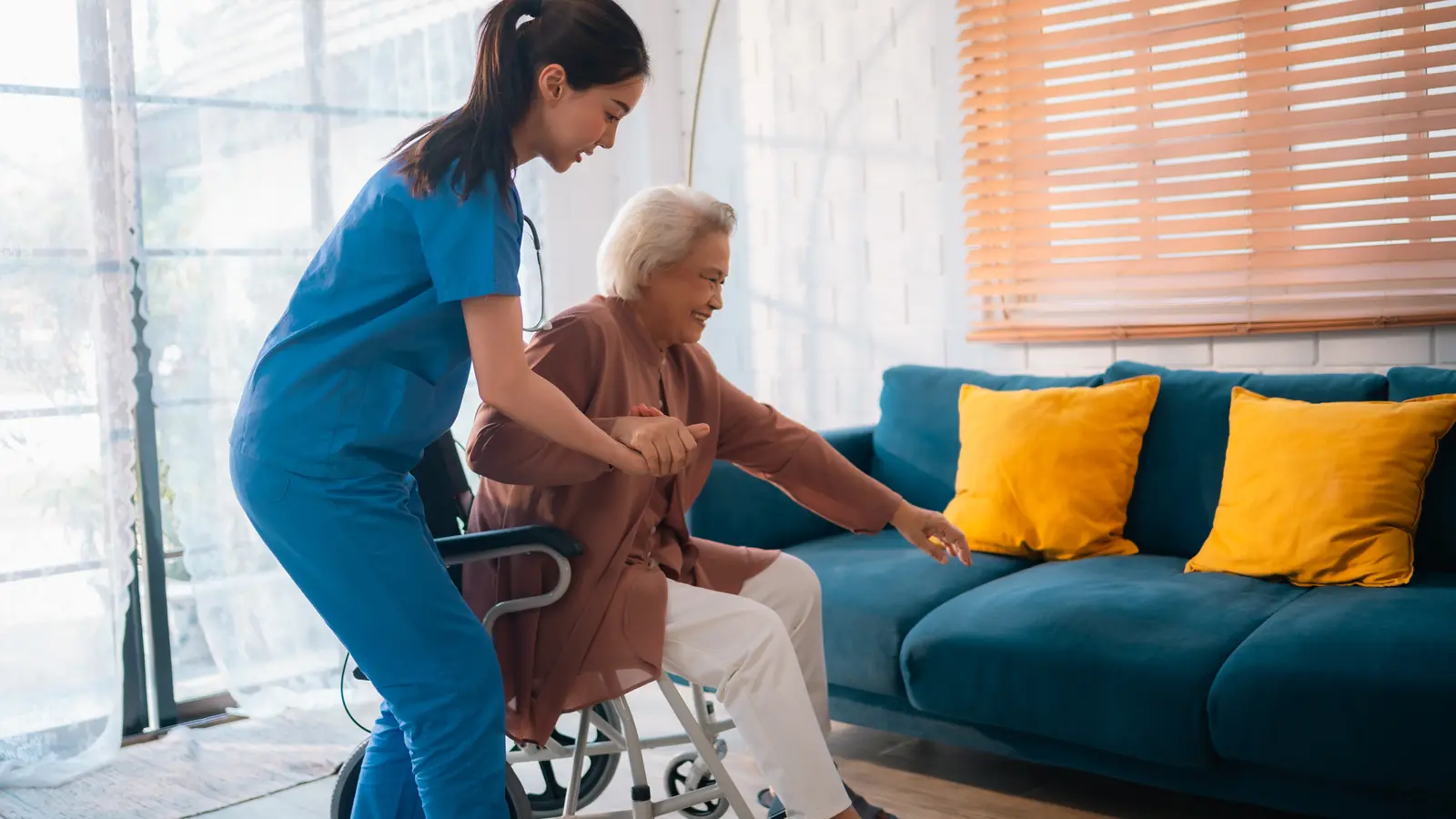 Noble Senior Care caregiver helping an older woman move safely from her wheelchair at home