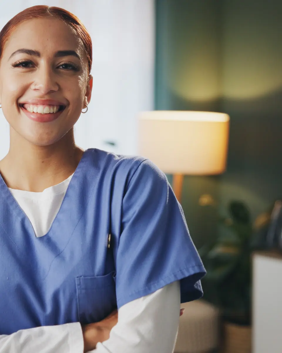 Smiling professional caregiver in blue scrubs